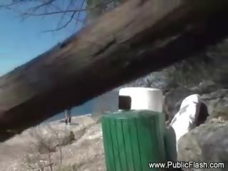 Attractive blond kvinne strimler fully naken på offentlig strand